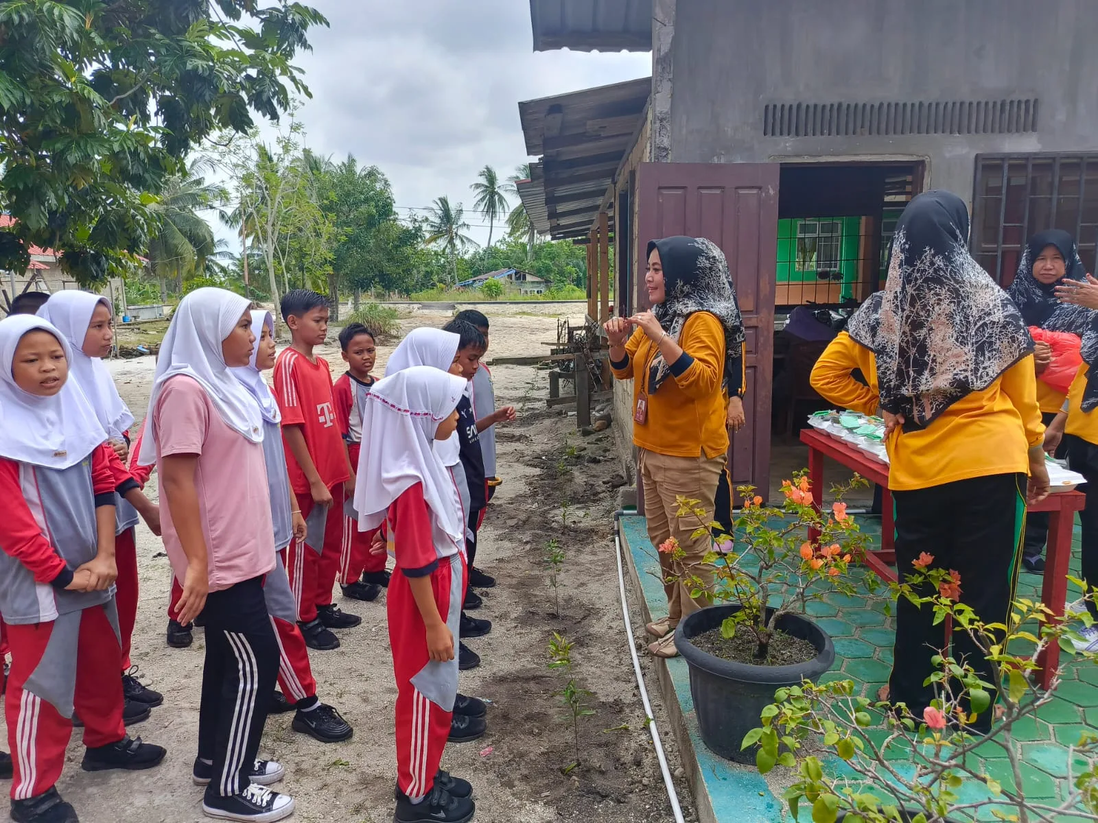 Kepala Sekolah SDN 005 Desa Parit, Rozalina, S.Pd. SD memberikan arahan kepada pelajar untuk merawat pohon hias yang ditanam | Foto: Ami